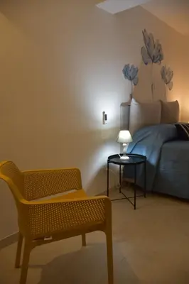 a bedroom with a bed and a chair and a table at Caladdaura in Palermo