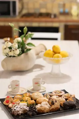 a table with a plate of pastries and a bowl of fruit at Villa Mare E Monti in Castellammare del Golfo