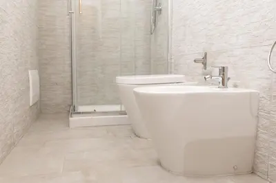 a white bathroom with a toilet and a shower at Villa Mare E Monti in Castellammare del Golfo