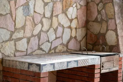 a stone wall with a bench in a room at Villa Mare E Monti in Castellammare del Golfo