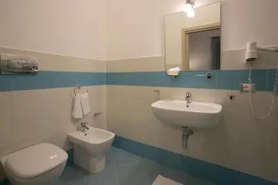 a bathroom with a sink and a toilet and a mirror at Rotte e Sentieri B&B in Castelluzzo