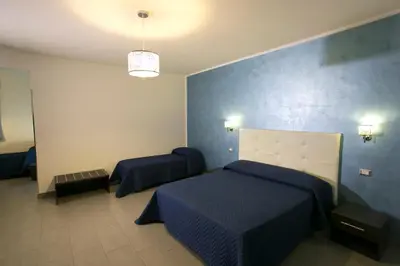 a bedroom with two beds and a blue wall at Rotte e Sentieri B&B in Castelluzzo
