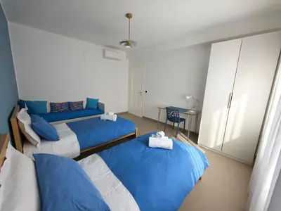 a bedroom with three blue beds and a table at Casa Zolì - Luxury House - 210mq in Palermo