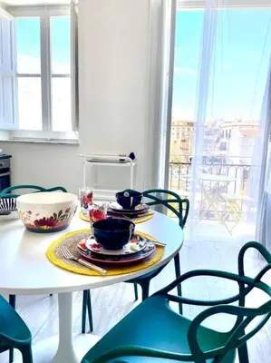 a table and chairs with plates and bowls on it at Monkey house Appartamento in centro storico in Palermo