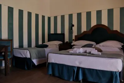 two beds in a room with striped walls at Villa Lampedusa in Palermo