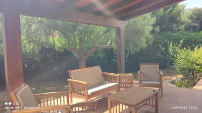 two chairs and a table on a patio with a tree at ViViHolidays in Castellammare del Golfo