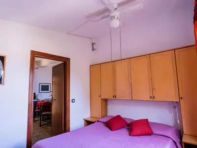 a bedroom with a purple bed and wooden cabinets at Apartment Sole by Interhome in Trappeto
