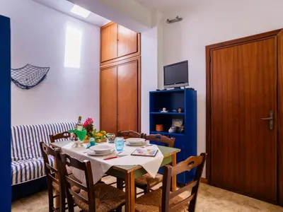 a dining room with a table and chairs and a television at Apartment Luna by Interhome in Trappeto