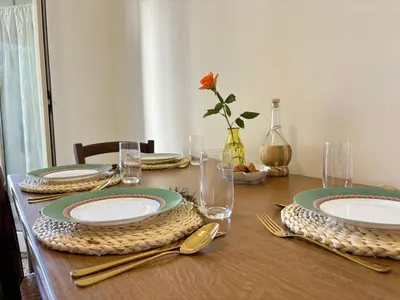 a wooden table with plates and utensils on it at Ekry Apartment in Palermo