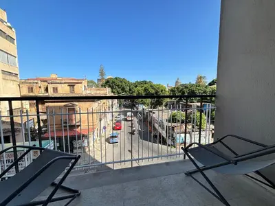 a balcony with two chairs and a view of a street at Ekry Apartment in Palermo