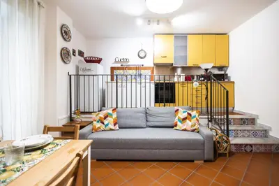 a living room with a couch and a kitchen at Ai Bottonai Casa 23 in Palermo