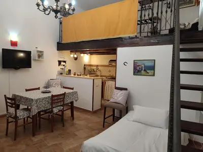 a room with a table and chairs and a kitchen at BONELLUS in Palermo