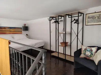 a bedroom with a crib and a bed and a chair at BONELLUS in Palermo