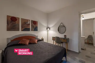 a bedroom with a bed and a desk and a mirror at Casa delle Travi by Wonderful Italy in Palermo