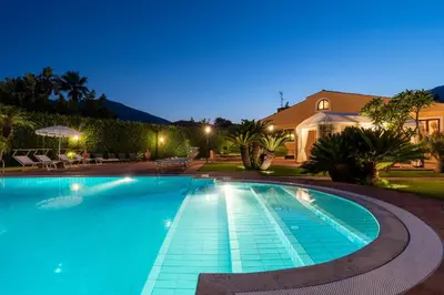 a swimming pool at night with a house in the background at Villa lady olimpia in Palermo