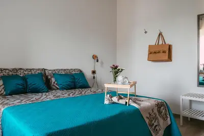 a bedroom with a blue bed and a white wall at Porta dei Mori Apartment in Palermo
