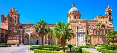 a large building with palm trees in front of it at Porta dei Mori Apartment in Palermo