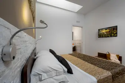 a bedroom with a bed and a lamp on the wall at Ayres Del Mar in San Vito lo Capo