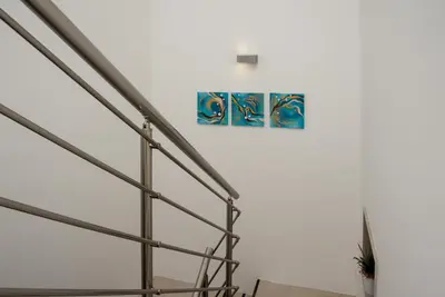 two paintings on a wall next to a staircase at Ayres Del Mar in San Vito lo Capo