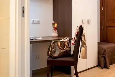 a hotel room with a desk with a purse on a chair at Ayres Del Mar in San Vito lo Capo