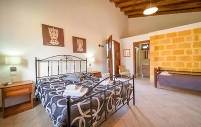 a bedroom with a bed in a room with a brick wall at Casale Del Golfo in Alcamo