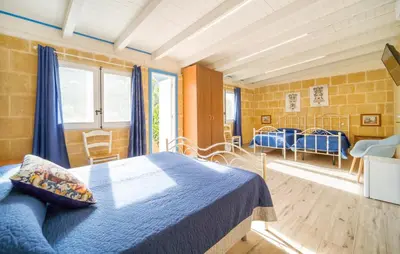 a bedroom with a blue bed in a room at Casale Del Golfo in Alcamo
