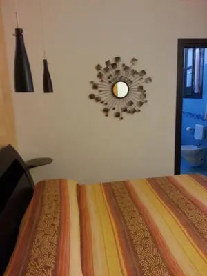 a bedroom with a bed and a mirror on the wall at Modus B&B in San Vito lo Capo