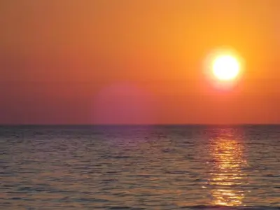 a sunset over the ocean with the sun in the sky at Modus B&B in San Vito lo Capo