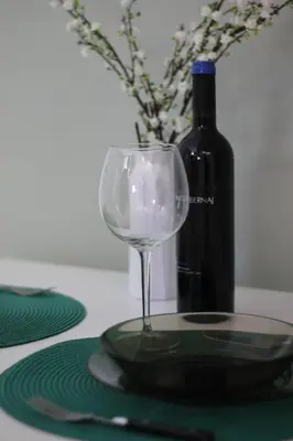 a wine glass sitting on a table with a bottle of wine at A' Nica room in Palermo