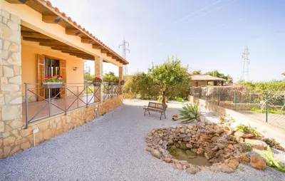 a house with a stone wall and a patio at Gorgeous Home In Altavilla Milicia in Altavilla Milicia