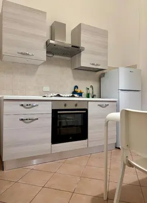 a kitchen with a stove and a refrigerator at Castelnuovo Rooms #Politeama in Palermo