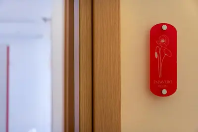 a red sign on a door with a flower on it at B&B Armonie in San Vito lo Capo