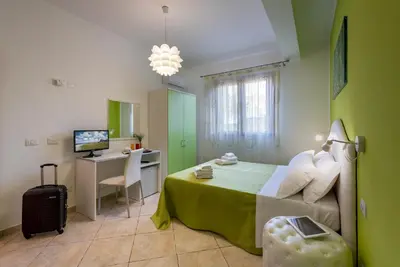 a bedroom with a bed and a desk with a computer at B&B Armonie in San Vito lo Capo
