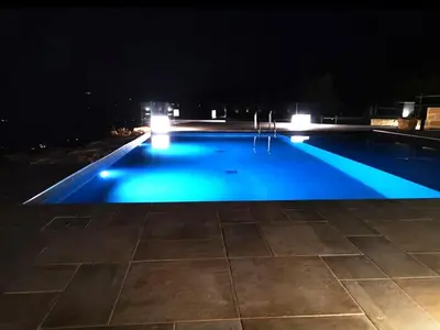 a swimming pool at night with blue lights at Villa Pharus Scopello in Scopello