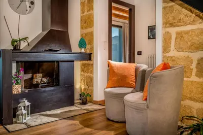 a living room with two chairs and a fireplace at Villa Pharus Scopello in Scopello