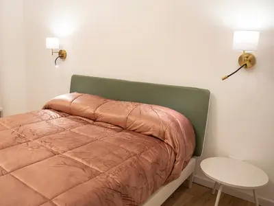 a bedroom with a bed and a table and lights at La Premiere Suite - Teatro Massimo Palermo in Palermo