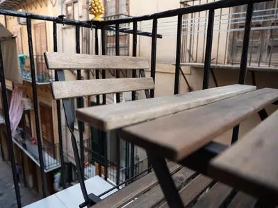 a wooden bench sitting on top of a balcony at La Premiere Suite - Teatro Massimo Palermo in Palermo