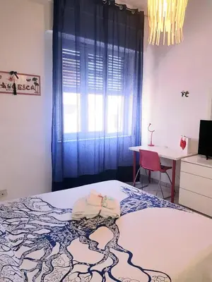 a bedroom with a bed and a desk and a window at Dolce casa centro storico di Palermo new 2023 in Palermo