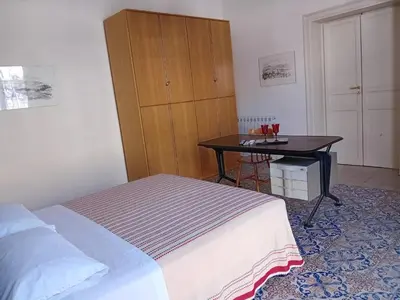a bedroom with a bed and a table with glasses on it at Casa nonno Enrico in via Oreto in Palermo