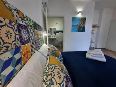 a bedroom with a bed with a blue bedspread at b&b Lastracu in Castellammare del Golfo