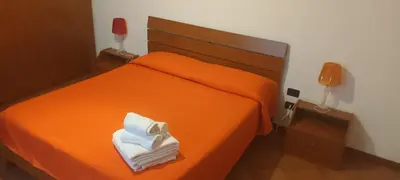 an orange bed with a pile of towels on it at Casa Vacanza Edy in Palermo