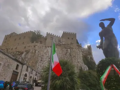a statue of a man standing in front of a castle at La casa sotto il castello in Caccamo