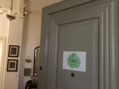a door with a green sign on it at G&G ROOMS in Palermo