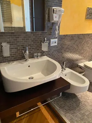 a bathroom with a white sink and a toilet at Casamu' Management Apartment Palermo in Palermo