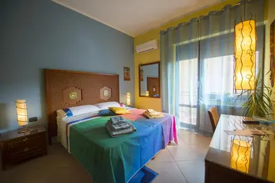 a bedroom with a bed with a blue blanket and a window at Dolce Conca D'Oro B&B in Palermo