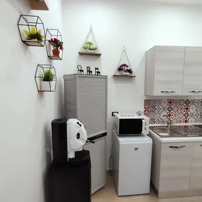 a small kitchen with a refrigerator and a microwave at La Casetta di Angy in Palermo