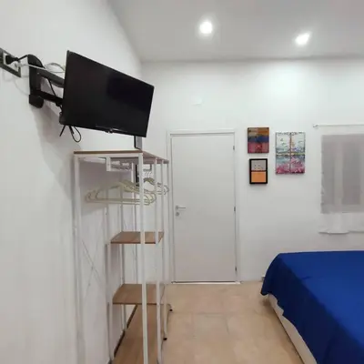 a room with a bed and a television on a shelf at La Casetta di Angy in Palermo