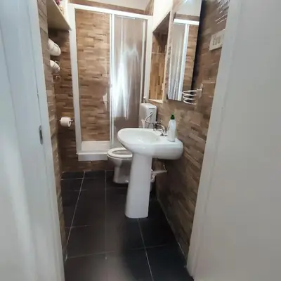 a bathroom with a white sink and a toilet at La Casetta di Angy in Palermo