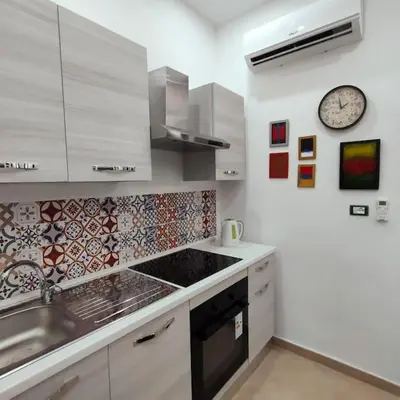 a kitchen with a sink and a clock on the wall at La Casetta di Angy in Palermo