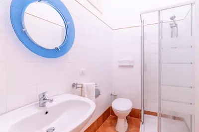 a bathroom with a mirror and a sink and a toilet at Viola's Luxury House in Palermo